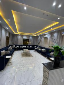 Ash Shishahشاليهات ميرامار مكة الحسينية的一间带蓝色沙发的客厅和一间大房间
