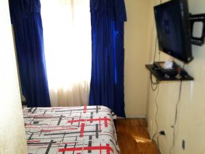 拉塔昆加Mountain Travel Ecuador的一间卧室配有一张床,并在一间客房内配有电视。