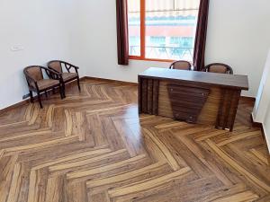 RajDarbar的配有桌椅和木地板的客房