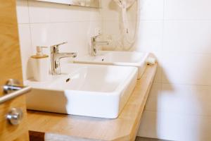 巴特黑灵Gasthof Franziskibad的白色的浴室设有水槽和淋浴。