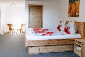 巴特黑灵Gasthof Franziskibad的一间卧室配有一张带红色枕头的木床。