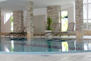 哥根巴赫根根巴赫黑森林酒店的一个带两把椅子的游泳池和一个游泳池