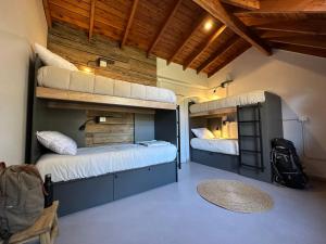 圣马丁德洛斯Warthon Hostel的带两张双层床和椅子的房间