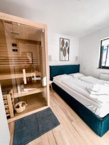 莫济列Sunshine Apartments Golte - Sauna的一间卧室设有一张带玻璃门的大床