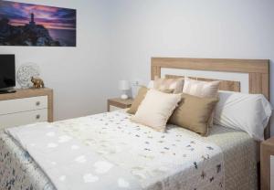 马尔皮卡AG Miramar Malpica x4 vistas playa Costa da Morte的一间卧室配有带枕头的床和电视。