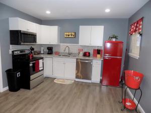 彭萨科拉Fishing Retreat的厨房配有红色冰箱和白色橱柜