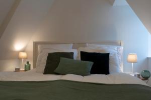 不莱梅Charmante Maisonette im Schnoor的一张带绿色和黑色枕头的白色床