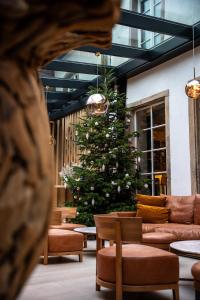 巴尔5 Terres Hôtel & Spa Barr - MGallery Hotel Collection的大堂的圣诞树,配有沙发和椅子