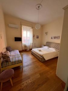 卡利亚里Appartamento centro storico Cagliari - Alter Nos house的一间卧室设有两张床、一把椅子和一个窗户。