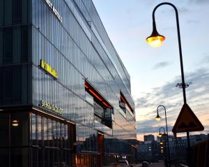 斯德哥尔摩Thon Partner Hotel Kungsbron的一座高大的玻璃建筑,旁边是街道灯