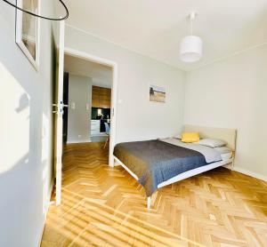 华沙Eastside Warsaw Apartment的一间卧室配有一张床,铺有木地板