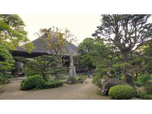 福岛Hotel Tenryukaku - Vacation STAY 16416v的一座花园,在一座建筑前有树木和灌木