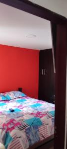 伊皮亚莱斯Ipiales puerta de oro的一间卧室配有一张红色墙壁的床