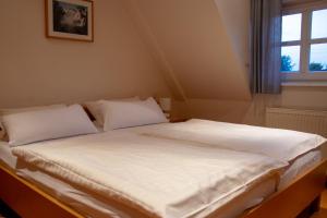 LastrupLandhaus Lastrup的一张带白色床单和枕头的床