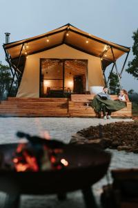 ExcelsiorAkuna Estate - Luxury Glamping Experience的两人坐在帐篷前