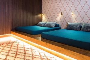 布鲁尼科ANTON Dolomites Hideaway的配有蓝色床单的客房内的两张床
