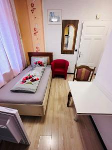 亚琛Gästezimmer Siminciuc的小房间设有一张床和一把红色椅子