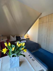 吕根岛上的维克Hotel-Pension Zur Mole的一间卧室,配有一张床,桌子上放着花瓶
