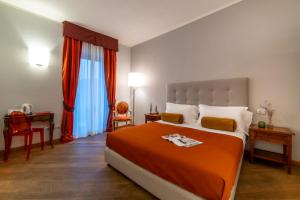 斯蒂亚Albergo Falterona的一间卧室配有一张带橙色毯子的大床