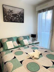 塞尔吉Cocon Eudenia - accès direct PARIS - 2 MIN RER - PARKING GRATUIT的一间卧室配有一张带绿色和白色枕头的大床