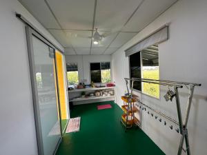 Simpang EmpatHomestay Denai Harummanis S4的一间设有健身房的客房,地面为绿色