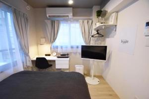 东京Ethos Ebisu 201 - Vacation STAY 09298v的一间卧室配有一张床、一张桌子和一台显示器
