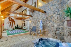 DumontRiverside Colorado Chalet with Deck and Hot Tub的一间设有石墙和浴缸的客房