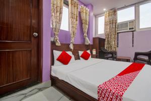 斋浦尔Hotel Rameshwaram的一间卧室配有红色枕头的床