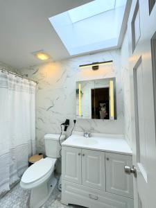皇后区The Waltham Private Room & Bathroom JFK LGA 10min I 20min ManhattanPenn Station bullet-train的浴室配有白色卫生间和盥洗盆。