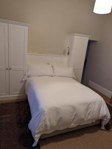 开普敦La Montagne Observatory的卧室配有白色的床和橱柜。