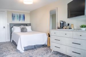 汉普顿935 Ocean, a Beachside Inn的卧室配有白色的床和梳妆台。