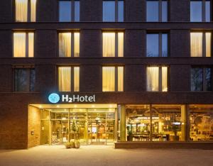 美因茨H2 Hotel Mainz的一座大型建筑,上面有h酒店标志