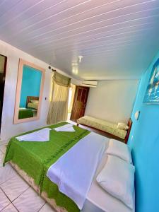 Ceará-MirimPousada Elpirata Sidney的一间卧室配有一张带绿毯的大床