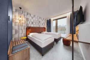 美因茨H2 Hotel Mainz的酒店客房设有两张床和窗户。