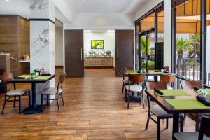 凤凰城菲尼克斯场北部假日套房酒店的餐厅铺有木地板,配有桌椅