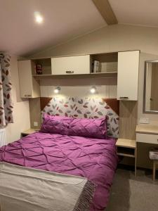 圣伦纳兹Foxglove Fourteen的一间卧室配有一张紫色的床和镜子