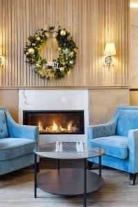 魁北克市皇家港景酒店的客厅配有2张蓝色沙发和壁炉