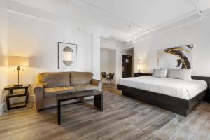 魁北克市皇家港景酒店的一间卧室配有一张床和一张沙发