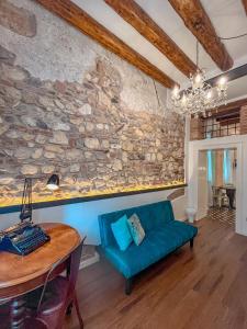 维罗纳Appartamento al Teatro Romano的客厅设有石墙和蓝色沙发。