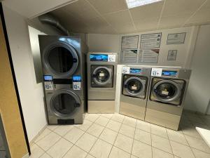 拉特里尼泰Sous les tropiques的洗衣房配有3台洗衣机和干衣机