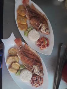 布兰卡滩Mi Cabañita Guest House的两盘食物,桌上有鱼