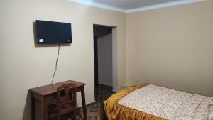 塔里哈The House Tarija的卧室配有一张床和壁挂式平面电视。