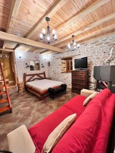 安吉斯乔治亚斯尼拉Magical cottage!的客厅配有红色的大沙发和床。