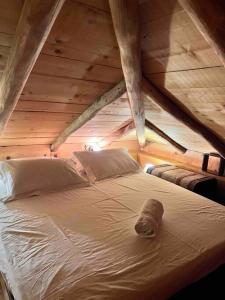 安吉斯乔治亚斯尼拉Magical cottage!的阁楼内的一张床铺,设有木制天花板
