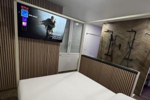 鲁昂Eaux Spa的一间墙上设有电视及视频游戏的房间