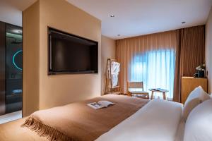 大理清渡 · 里院 (大理古城店)的酒店客房,设有一张带平面电视的床铺。