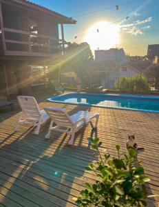 南卡希亚斯Casa do Rogério Hostel的一个带两把椅子的庭院和一个游泳池