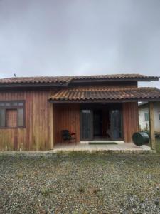 南圣弗朗西斯科Casa de Veraneio em São Francisco do Sul - Praia do Ervino的一个小房子,设有门廊和庭院