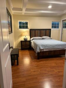 East Palo AltoPrivate room near Facebook, Amazon, Stanford的一间卧室配有一张床,铺有木地板
