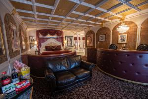 博伊西The Anniversary Inn - Boise的客厅配有真皮座椅和床